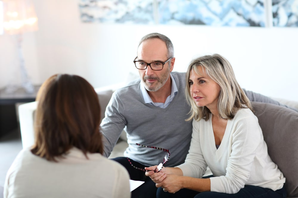 An elderly couple speaks with a lawyer about estate planning.