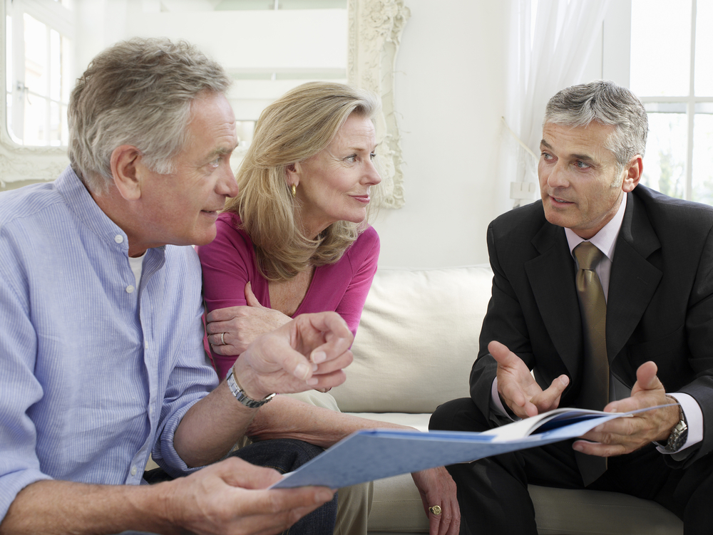 Lawyer explaining to an older couple how to distribute trust assets to beneficiaries